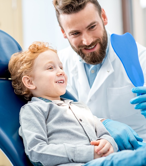 Dentist showing boy his smile in the mirror