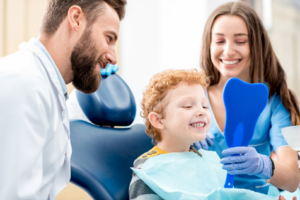 Family dentist showing a kid his teeth in a mirror